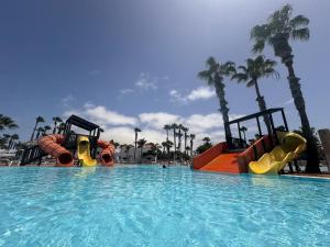 a swimming pool with a water slide in a resort at Oasis Jaylota in Corralejo