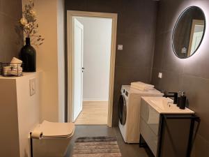 a bathroom with a washing machine and a mirror at Estonia Premium Living - Observatory Deluxe Stay in Tyravere +27 photos