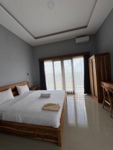 a bedroom with a large bed and a window at Belong guest house in Mantaak