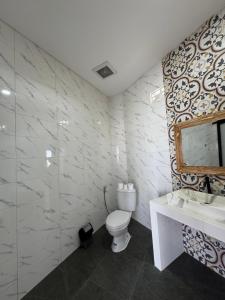 a bathroom with a toilet and a sink and a mirror at Belong guest house in Mantaak