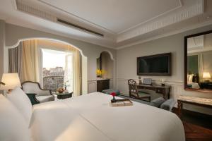 a bedroom with a large white bed and a television at La Mejor Indochine Hotel in Hanoi +140 photos