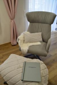a living room with a chair with a book on it at Ferienwohnung Mühlenanger in Quedlinburg