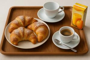 a tray with a plate of croissants and a cup of coffee at B&B Maestra Giovanna in Pompei