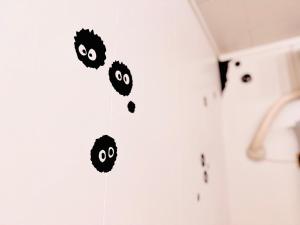 a group of black faces on a white wall at SETO8 House in Seto