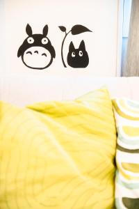 two black cats stencils on a wall above a bed at SETO8 House in Seto +31 photos