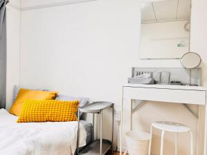 a white bedroom with a bed and a desk at SETO8 House in Seto