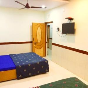 にあるTirth Hotelのベッドとテレビがある部屋