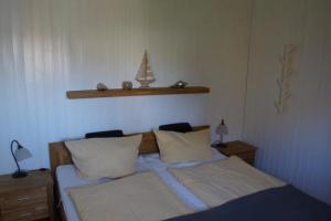 a bedroom with a bed with two pillows at Kinderfreundliches 6 Personen Ferienhaus mit zwei Duschen und Toiletten, Sauna, Whirlpool und einem Wintergarten mit Kaminofen in Otterndorf in Otterndorf
