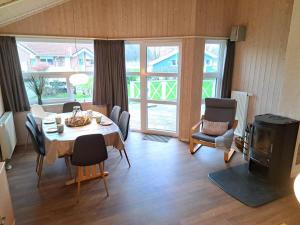 a dining room with a table and chairs and a room with a window at 6 Personen Ferienhaus mit Sauna, Whirlpool, Kaminofen und Kanu in 2. Rheie zum See in Otterndorf in Otterndorf