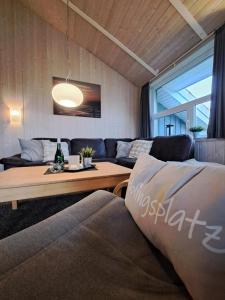 a living room with a couch and a table at 6 Personen Ferienhaus mit Sauna, Whirlpool, Kaminofen und Kanu in 2. Rheie zum See in Otterndorf in Otterndorf