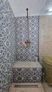 un bagno con una parete piastrellata e un lampadario a braccio di Dar El Aalia Sea View Stay in Iconic Sidi Bou Saïd a Sidi Bou Saïd