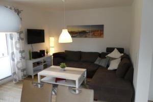 a living room with a couch and a table at 6 Personen Ferienhaus mit zwei Duschen und Toiletten, Sauna, Whirlpool und Kaminofen in Otterndorf in Otterndorf