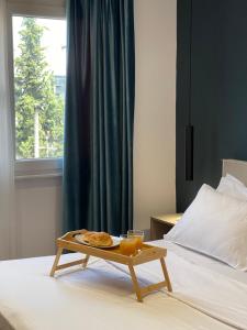 bandeja con comida y bebida en la cama en Central Modern Apartment, en Tirana