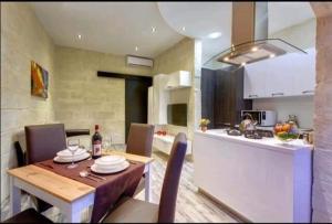 a kitchen and a dining room with a table and a kitchen at Seafront 1 bedroom Maisonette in Kalkara
