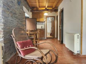 une chaise à bascule dans une pièce avec une cuisine dans l'établissement Valles del Narcea, Apartamentos Rurales, à Cangas del Narcea