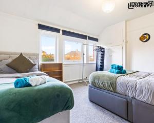 a bedroom with two beds and a window at Group Stays, 4 Bedroom, Spacious Home in BS4, Van & Car Parking, Sleeps 7 in Bristol