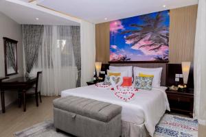 a hotel room with a large bed and a desk at Royal Suites Hotel-Kampala in Kampala