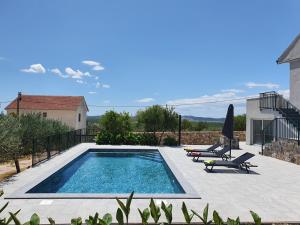a swimming pool with two lounge chairs at Villa Lidia in Lađevci
