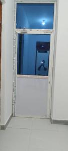 a glass door in a room with a person in the water at Maga Apartment in Kinyasini