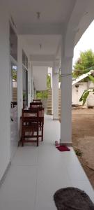 an empty porch of a white house with a table at Maga Apartment in Kinyasini