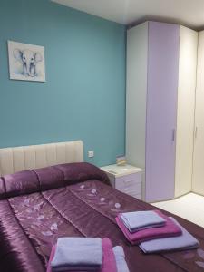 a bedroom with a purple bed with towels on it at Modern, stylish & comfortable 3 bedroom apartment with jacuzzi and private yard with barbeque in Mellieħa