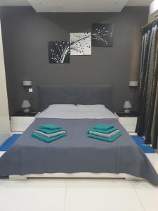 a bedroom with a bed with three towels on it at Modern, stylish & comfortable 3 bedroom apartment with jacuzzi and private yard with barbeque in Mellieħa