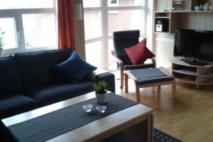 a living room with a couch and a coffee table at 6 Personen Ferienhaus mit privatem Bootsteg, dikekter Seelage, Kanu, Whirlpool, Sauna und Kaminofen in Otterndorf in Otterndorf