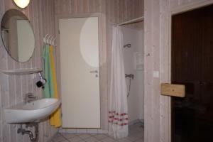 a bathroom with a sink and a shower and a mirror at 6 Personen Ferienhaus mit privatem Bootsteg, dikekter Seelage, Kanu, Whirlpool, Sauna und Kaminofen in Otterndorf in Otterndorf +13 photos