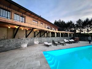 a swimming pool with chairs and a building at Mergen Bike & Ski Resort in Niedzica Zamek