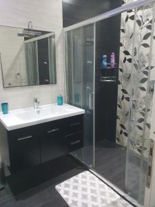 a bathroom with a sink and a shower with a mirror at Modern, stylish & comfortable 3 bedroom apartment with jacuzzi and private yard with barbeque in Mellieħa +38 photos