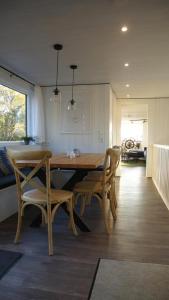 ein Esszimmer mit einem Holztisch und Stühlen in der Unterkunft 8 Personen Hausboot mit Hot Tub, Sauna, Kaminofen, Klimaanlage, Lounge, Sonnendeck und Garten mit Buddelschiff direkt hinterm Deich in Otterndorf in Otterndorf