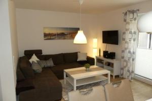 a living room with a couch and a table at 6 Personen Ferienhaus mit Sauna, Whirlpool, zwei Duschen sowie Kaminofen in Otterndorf in Otterndorf