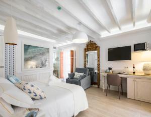a white room with a bed and a desk and a chair at Son Sant Jordi in Pollença