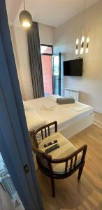 a room with two beds and a table and a chair at Seventh Floor Apartment in Kutaisi