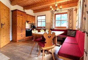 una cucina con tavolo e divano rosso di Almliesl HUET-484 a Hüttschlag