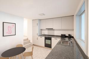 a kitchen with white cabinets and a table and a table at La Sauvage in Fribourg