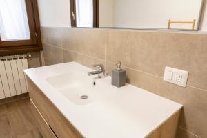 un bagno con un lavandino bianco e uno specchio di Cima del ricordo a Pontagna Altre 12 foto