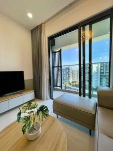 a living room with a couch and a large window at Apartment Alnata Diamond 2 Bedrooms Celadon City in Kon Rung (1)