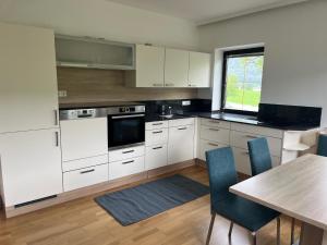 a kitchen with white cabinets and a table with chairs at Ferienwohnung Gegenhaus in Weberstorf