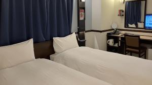 Toyoko Inn Tokyo Akiba Asakusabashi-eki Higashi-guchi في طوكيو: غرفة فندقية بسريرين ومكتب فيه كمبيوتر