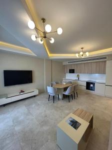 a large living room with a table and a tv at Sea Breeze The Grand 347 in Nardaran