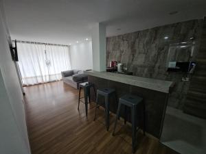 a kitchen with a counter and stools in a room at Hospedaria Santiago in Teresópolis