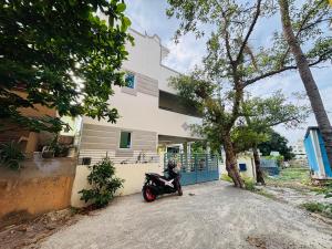 a person sitting on a motorcycle in front of a building at SHI's Agam Bed & Breakfast at Chennai in Chennai