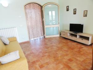 a living room with a television and a wooden floor at Poggio Novello in Peccioli