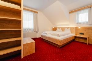 una camera con letto e tappeto rosso di Glautschhof a Weissensee