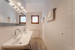 un bagno bianco con due lavandini e uno specchio di Glautschhof a Weissensee