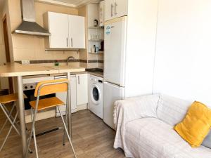 kuchnia z lodówką, stołem i krzesłem w obiekcie Apartamento coqueto w Maladze