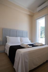 Lido degli Angeli Case Vacanza-Beach في بونتا بروسسيوتو: غرفة نوم بها سرير كبير عليه منشفتين