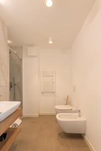 a bathroom with two toilets and a sink and a tub at Luminoso Trilocale Certosa - Mirable PM in Milan +22 photos