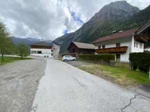 a road with a car parked in front of a house at Haus Praxmarer in Kaunertal